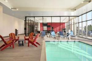 um átrio com uma piscina, cadeiras e uma mesa em Home2 Suites By Hilton Woodland Hills Los Angeles em Woodland Hills