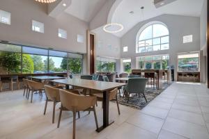 Homewood Suites Lansdale في لانسديل: غرفة طعام مع طاولات وكراسي ونوافذ
