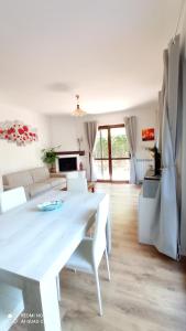 a white living room with a white table and chairs at Il Giardino Fiorito in Trevignano Romano