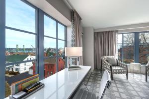 a living room with a table and a large window at Hilton Garden Inn Portsmouth Downtown in Portsmouth