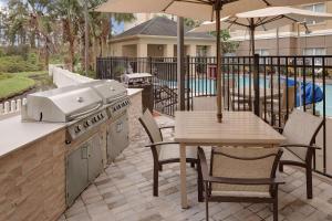 a outdoor patio with a grill and a table with a table at Homewood Suites by Hilton Orlando Maitland in Orlando