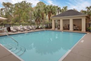 a large swimming pool with chairs and a house at Homewood Suites by Hilton Orlando Maitland in Orlando
