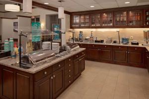 une grande cuisine avec des placards en bois et un comptoir. dans l'établissement Homewood Suites by Hilton Orlando Maitland, à Orlando