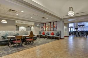 eine Lobby mit Sofas, einem Tisch und Stühlen in der Unterkunft Hampton Inn & Suites Newark-Harrison-Riverwalk in Newark