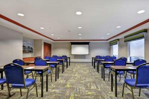 a conference room with tables and chairs and a screen at Hampton Inn & Suites Newark-Harrison-Riverwalk in Newark