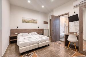 a bedroom with a bed and a desk and a television at Hotel Ristorante Il Caminetto in Diano Marina