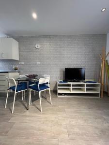 a kitchen with a table and chairs and a television at El Cortijo Bungallows in Playa de las Americas