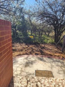 eine Terrasse mit Ziegelwand und Treppe in der Unterkunft Crimson Bush Lodge in Klipdrift