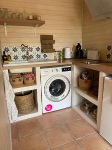 uma lavandaria com uma máquina de lavar roupa na cozinha em Studio chalet Bassin d’Arcachon em Mios