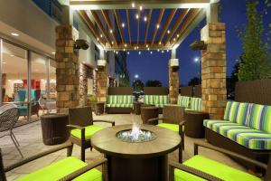 un patio con una hoguera, mesas y sillas en Home2 Suites by Hilton Seattle Airport, en Tukwila