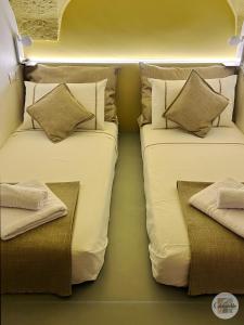 two beds sitting next to each other in a room at Calamedde Guest House nel Centro Storico Pugliese in Fasano