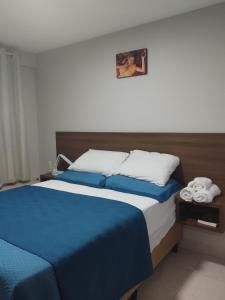 a bedroom with a large bed with blue sheets at Flat Jardins do Atlântico, frente mar in João Pessoa