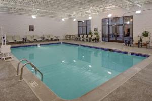 a large swimming pool in a building with chairs and tables at Homewood Suites by Hilton Minneapolis-Mall Of America in Bloomington