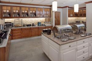 Homewood Suites by Hilton Minneapolis-Mall Of America في بلومنغتون: مطبخ كبير مع دواليب خشبية وقمة كونتر