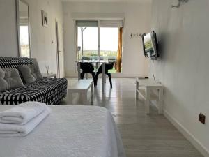 ein Wohnzimmer mit einem Sofa und einem Tisch mit einem TV in der Unterkunft Mi pequeño ático con vistas in Córdoba