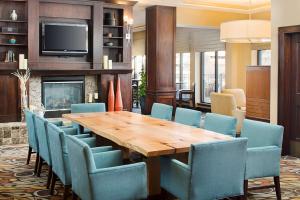 a dining room with a wooden table and blue chairs at Hilton Garden Inn Denver Tech Center in Denver