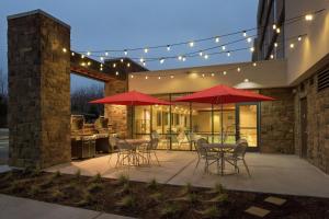 patio z czerwonymi parasolami, stołami i krzesłami w obiekcie Home2 Suites by Hilton Salt Lake City / South Jordan w mieście South Jordan
