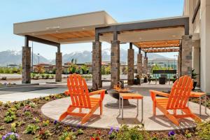two orange chairs and a fire pit on a patio at Home2 Suites by Hilton Salt Lake City / South Jordan in South Jordan