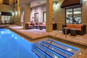una piscina nella hall dell'hotel con divani e sedie di Homewood Suites by Hilton Jacksonville-Downtown/Southbank a Jacksonville