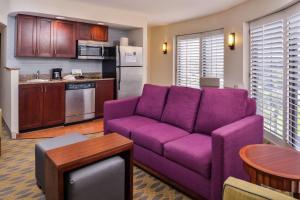 uma sala de estar com um sofá roxo e uma cozinha em Homewood Suites by Hilton Jacksonville-Downtown/Southbank em Jacksonville