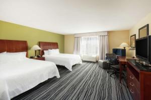 a hotel room with two beds and a flat screen tv at Hilton Garden Inn St. Louis Shiloh/O'Fallon IL in O'Fallon