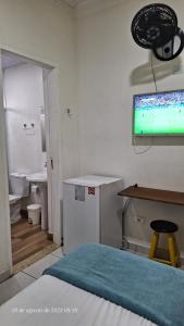 a hospital room with a bed and a tv on the wall at Hospedagem Camisa 10 in Santos