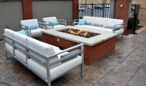 eine Terrasse mit einer Feuerstelle mit Stühlen und einem Sofa in der Unterkunft Embassy Suites by Hilton Atlanta NE Gwinnett Sugarloaf in Duluth