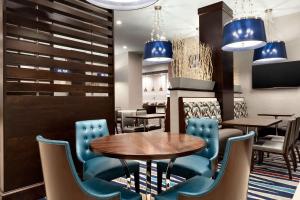 a dining room with a table and blue chairs at Embassy Suites by Hilton Atlanta NE Gwinnett Sugarloaf in Duluth