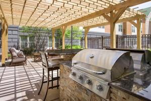 an outdoor kitchen with a grill on a patio at Homewood Suites by Hilton Dulles-North Loudoun in Ashburn