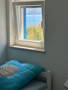 Dormitorio con ventana con cama y océano en Ražanac Apartments, en Ražanac