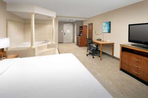 a hotel room with a bed and a flat screen tv at Hilton Garden Inn Atlanta West/Lithia Springs in Lithia Springs