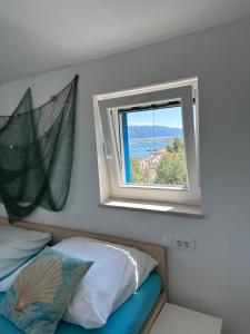 Dormitorio con ventana con cama y vistas en Ražanac Apartments, en Ražanac