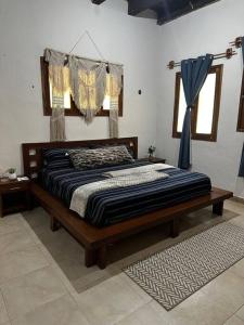 uma cama grande num quarto com uma cortina azul em Villa Pedacito de Cielo em Leona Vicario