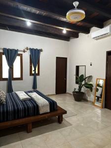 um quarto com uma cama com cortinas azuis em Villa Pedacito de Cielo em Leona Vicario