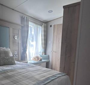Schlafzimmer mit einem Bett und einem Fenster in der Unterkunft Sandy Toes, Padstow in Padstow