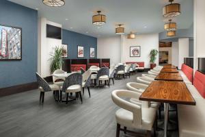 Embassy Suites by Hilton Birmingham Hoover في هوفر: غرفة انتظار مع طاولات وكراسي في مطعم
