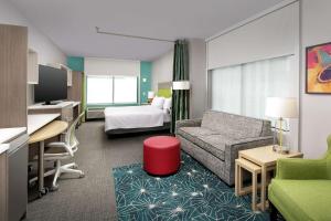 um quarto de hotel com um sofá e uma cama em Home2 Suites By Hilton Nashville Downtown Convention Center em Nashville