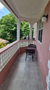 a balcony with a table and a bench on it at vacation home in Roseau