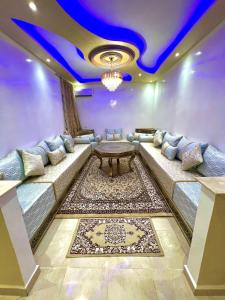 una sala de estar con un sofá y una mesa en Superbe Appartement proche centre marrakech, neuf tout équipé, en Marrakech