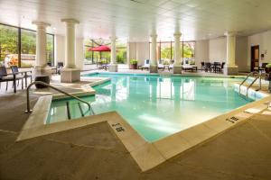 - une piscine dans un hôtel avec des tables et des chaises dans l'établissement DoubleTree by Hilton Hotel Largo Washington DC, à Largo