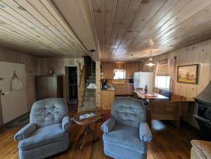 a living room with two chairs and a kitchen at Moore's Cabin in Miramonte