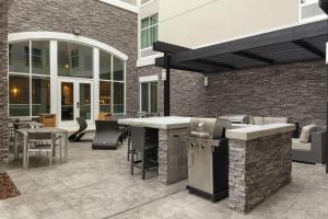 un patio con parrilla y sillas y un edificio en Homewood Suites By Hilton Largo Washington Dc, en Largo