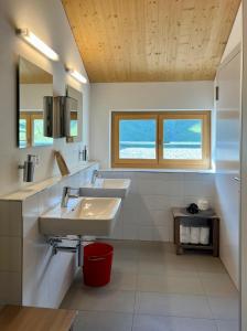 ein Badezimmer mit zwei Waschbecken und zwei Fenstern in der Unterkunft Ospizio La Veduta in Bivio