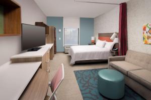 マーフリーズボロにあるHome2 Suites By Hilton Murfreesboroのベッドとリビングルームが備わるホテルルームです。
