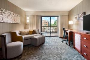 a living room with a couch and a desk with a television at Courtyard Akron Fairlawn in Montrose