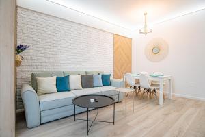 - un salon avec un canapé et une table dans l'établissement GooApartments Five, à Mamaia Nord – Năvodari