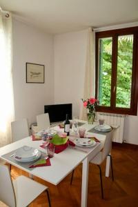 a white dining room table with white chairs and a white tableablish at Isola del Lido, Luminoso, immerso nel verde, per 5 in Venice-Lido