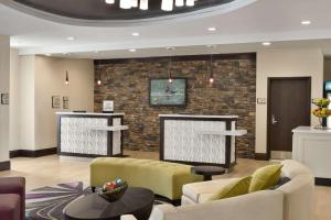 a lobby with two couches and a brick wall at Homewood Suites Mobile in Mobile