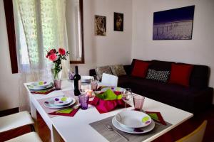 a living room with a white table with plates and glasses at Isola del Lido, Luminoso, immerso nel verde, per 5 in Venice-Lido +39 photos