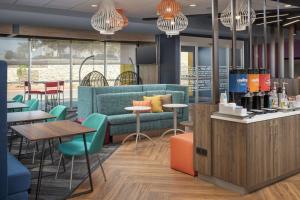 a restaurant with a blue couch and tables and chairs at Tru By Hilton El Paso Northeast in Homestead Meadows South